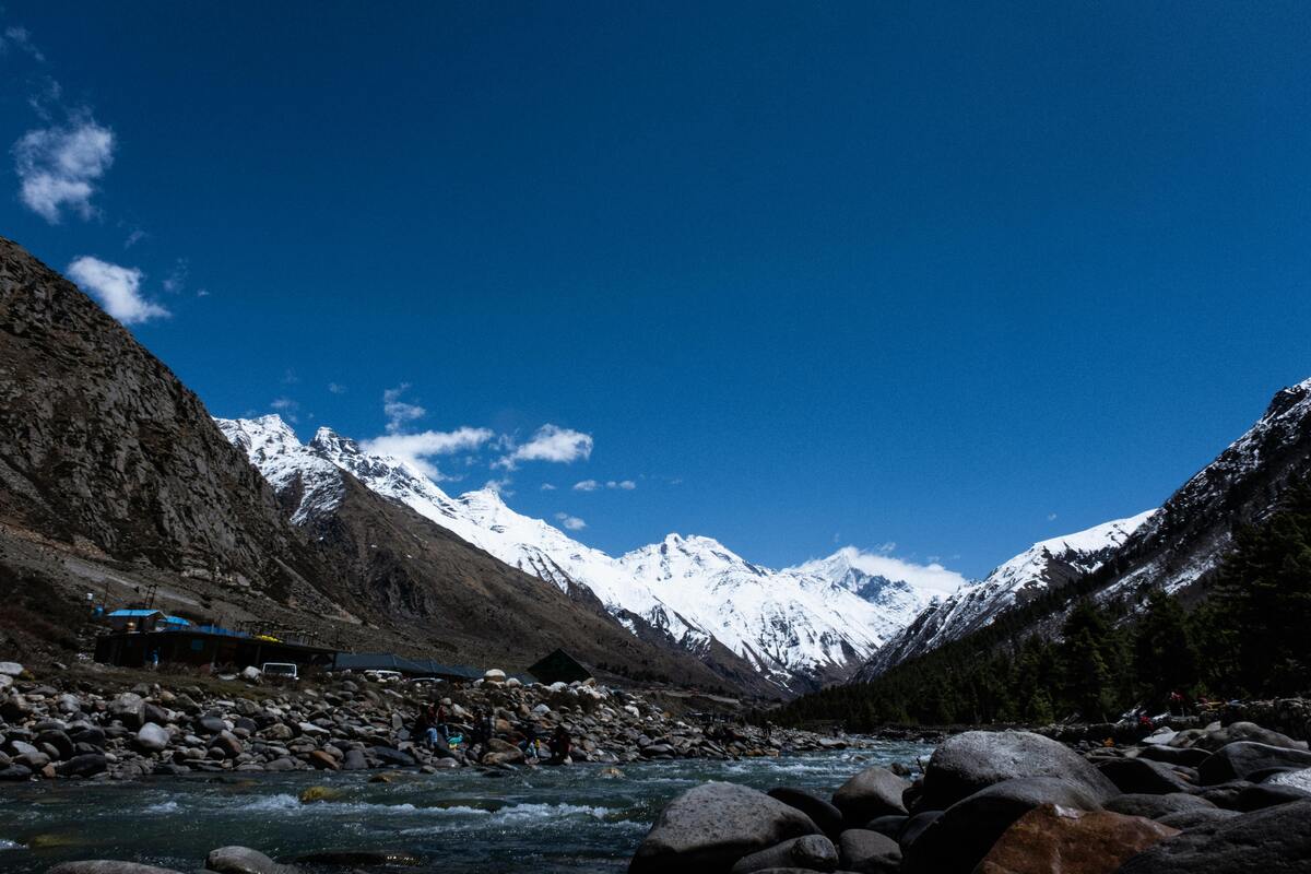 Fragile Himalayan ecosystem with mountains, forests, and village showing environmental sensitivity